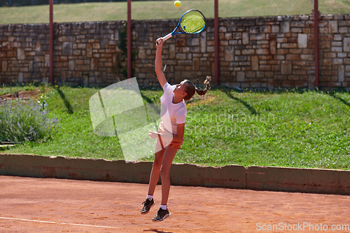 Image of A young girl showing professional tennis skills in a competitive match on a sunny day, surrounded by the modern aesthetics of a tennis court.