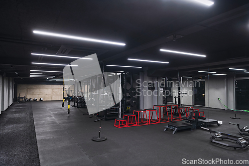 Image of An empty modern gymnasium with a variety of equipment, offering a spacious, functional, and well-equipped training facility for workouts, fitness, and strength training