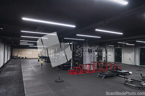 Image of An empty modern gymnasium with a variety of equipment, offering a spacious, functional, and well-equipped training facility for workouts, fitness, and strength training