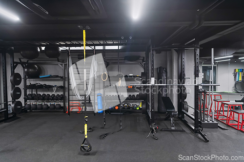 Image of An empty modern gymnasium with a variety of equipment, offering a spacious, functional, and well-equipped training facility for workouts, fitness, and strength training