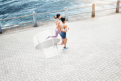 Image of Beach, women and fitness friends running on sidewalk at the ocean for exercise, cardio workout and training outdoors. Healthy, wellness and sports runners exercising together at sea or waterfront