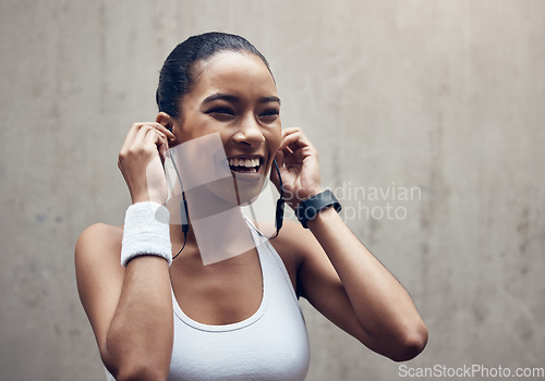 Image of Music, fitness and exercise with a sports woman streaming audio during training or a workout on a gray background. Health, cardio and training with a female runner listening on earphones during a run