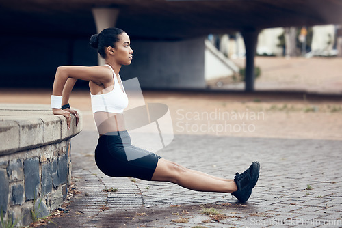 Image of City exercise, woman and dips workout, fitness and challenge for wellness, focus mindset and urban training in Brazil. Young sports athlete, tricep stretching and power for body muscle performance