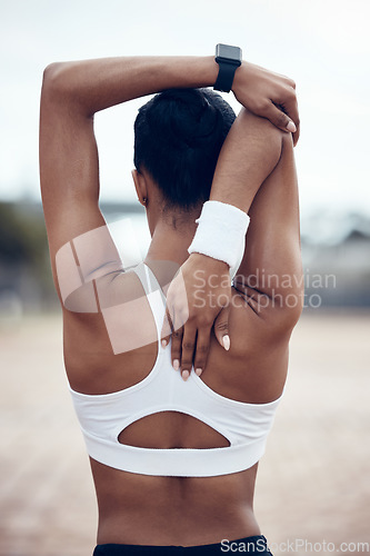 Image of Fitness, sports and woman runner stretching arm for exercise, cardio workout and training running performance. Wellness, commitment and back view of healthy girl doing a warm up for marathon practice