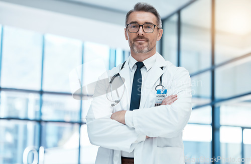 Image of Doctor, senior man and arms crossed with glasses and stethoscope in medical healthcare clinic. Health medic research expert, science innovation leader and proud professional surgeon in hospital