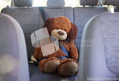 Image of Teddy bear, seatbelt and safety on the back seat of a car while on a road trip, journey and travel with transport, insurance and vehicle. Passenger, protect and safe driving with a stuffed animal toy