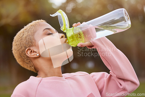 Image of Fitness, water bottle and woman outdoor in nature park for exercise, training and run for health, wellness and hydration during workout. Fit athlete female feeling thirsty and drinking healthy drink
