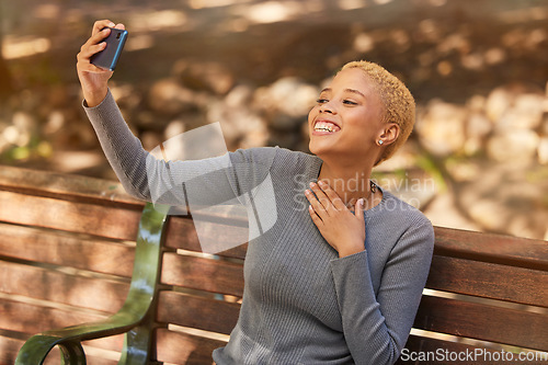 Image of Park bench, phone selfie and black woman in nature outdoors taking picture. Happy, smile and girl from South Africa with 5g mobile for photo, social media post or comic memory alone at park outside.