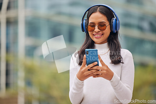 Image of Phone, woman and music in a city with happy, relax and smiling female walking, texting and chatting online. Radio, podcast and audio streaming with trendy lady enjoying subscription service in town