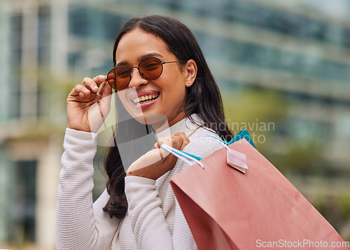 Image of Shopping bag, retail and portrait of woman with sunglasses walking in city after store sale or discount. Happy, smile and rich posh housewife from Mexico shopping for fashion clothes in urban town.