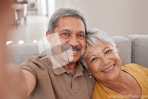 Image of Selfie, couple and love with a senior man and woman sitting on the sofa of their home together for a photograph. Portrait, love and smile with elderly pensioners taking a picture in the living room