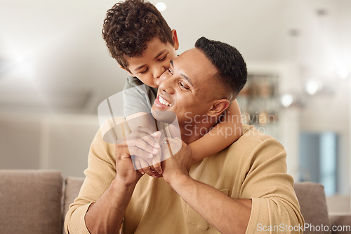 Image of Kiss, child and father with hug on the sofa for love, care and happiness in the living room together in their house. Young, happy and kid with smile, affection and hugging his dad on the couch