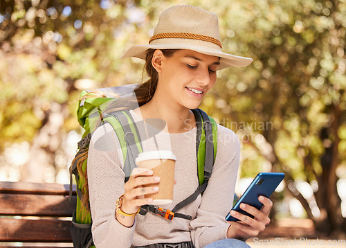 Image of Phone, coffee and travel with a woman backpacker using 5g mobile technology for directions or navigation in a park. Social media, tourism and communication with a young woman typing a text message