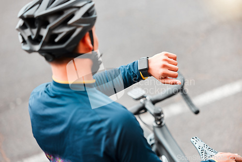 Image of Watch, fitness and man cycling in the city on a bike for cardio health, exercise and sustainable lifestyle. Athlete cyclist training with the time on tech with a bicycle on the street for motivation