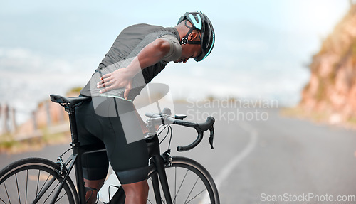 Image of Fitness, sports injury and back pain by man cyclist feel uncomfortable while cycling along mountain route. Training, pain and injured athletic guy suffering from joint, muscle and spinal discomfort