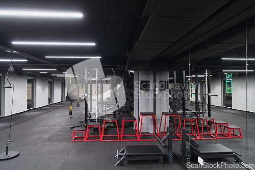 Image of An empty modern gymnasium with a variety of equipment, offering a spacious, functional, and well-equipped training facility for workouts, fitness, and strength training