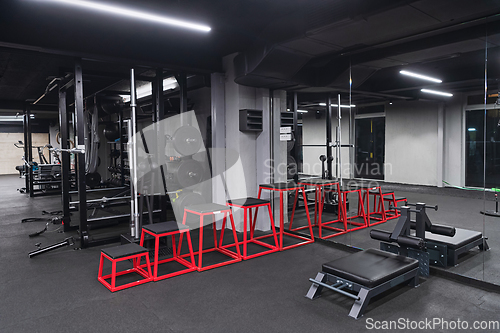 Image of An empty modern gymnasium with a variety of equipment, offering a spacious, functional, and well-equipped training facility for workouts, fitness, and strength training