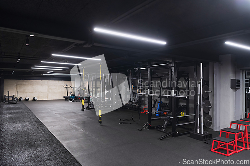 Image of An empty modern gymnasium with a variety of equipment, offering a spacious, functional, and well-equipped training facility for workouts, fitness, and strength training