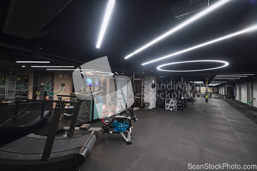 Image of An empty modern gymnasium with a variety of equipment, offering a spacious, functional, and well-equipped training facility for workouts, fitness, and strength training