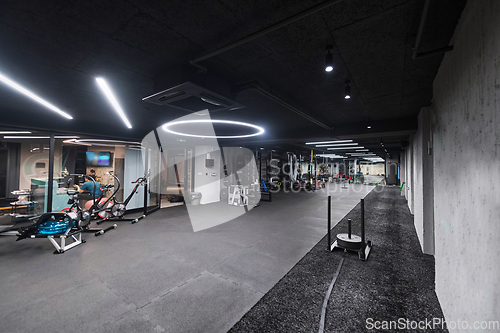 Image of An empty modern gymnasium with a variety of equipment, offering a spacious, functional, and well-equipped training facility for workouts, fitness, and strength training