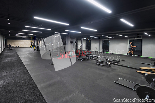 Image of An empty modern gymnasium with a variety of equipment, offering a spacious, functional, and well-equipped training facility for workouts, fitness, and strength training
