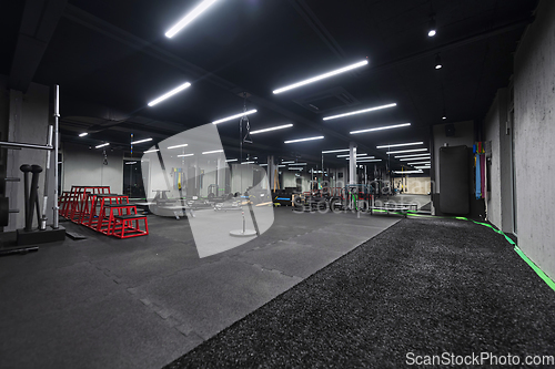 Image of An empty modern gymnasium with a variety of equipment, offering a spacious, functional, and well-equipped training facility for workouts, fitness, and strength training