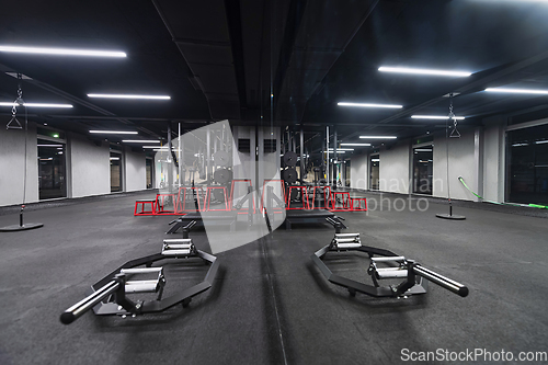 Image of An empty modern gymnasium with a variety of equipment, offering a spacious, functional, and well-equipped training facility for workouts, fitness, and strength training