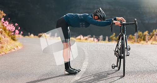 Image of Bike, street cycling and stretching with a sports man at the start of fitness, exercise or training on an asphalt road. Bicycle, stretch and workout with a male cyclist getting ready for a sport ride