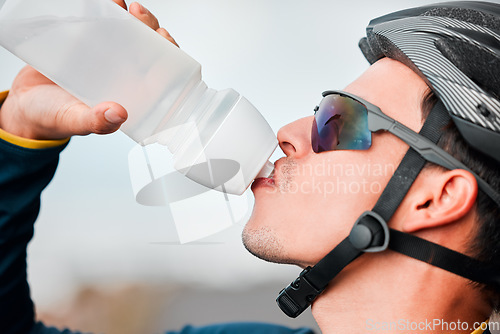 Image of Fitness, cycling and man drinking water in bottle during a cycle marathon, training or exercise. Cardio, sports and thirsty biker athlete enjoying a refreshing drink, liquid or beverage while biking.