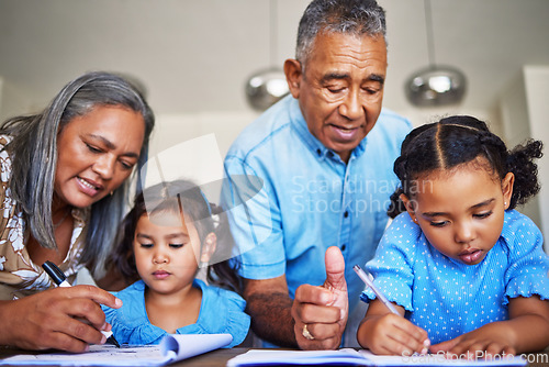 Image of Homework, writing and grandparents helping children with education together at a table in their house. Girl kids learning in a notebook with a senior man and woman teaching, studying and giving help