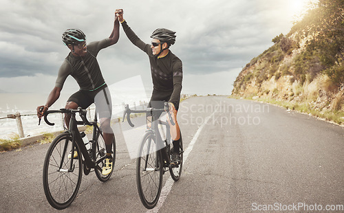 Image of Bike, friends and men high five on road having fun cycling together outdoors. Success, diversity and teamwork of male cyclists on bicycles riding on street, exercise or workout training on asphalt.