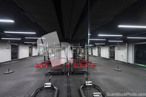 Image of An empty modern gymnasium with a variety of equipment, offering a spacious, functional, and well-equipped training facility for workouts, fitness, and strength training