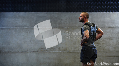 Image of A muscular man in the gym, preparing for his workout, exudes determination and focus as he gets ready to push his limits and achieve his fitness goals.