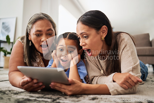 Image of Digital tablet, family and wow in a living room with multigenerational women bonding on a floor, surprised, shock and excited. Relax, happy family and good news with mother, girl and grandma online