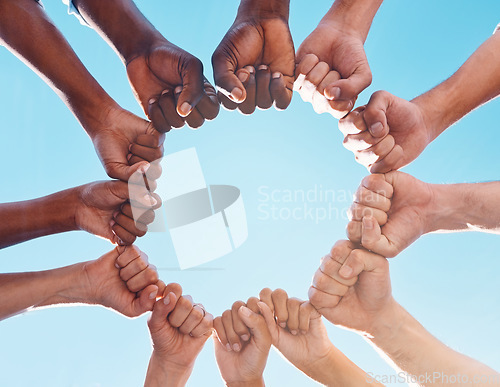 Image of Fist hands, circle and diversity support human rights people, protest group and freedom of racism on blue sky background. Below solidarity, partnership and motivation of goals, trust or world justice