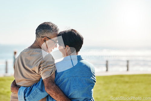 Image of Hug, love and senior couple at the beach for a holiday in Brazil during retirement in summer. Back of a relax, happy and elderly man and woman hugging with affection on a travel vacation by the sea