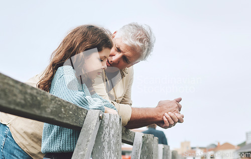 Image of Talking, children and love with a girl and grandfather bonding or spending time together outdoor on a pier. Conversation, care and relationship with a senior man and granddaughter chatting outside
