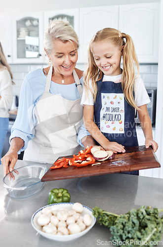 Image of Cooking, child and grandmother teaching a girl our to cook healthy food with nutrition in the kitchen of their house. Happy, smile and young kid learning about vegetables with an elderly woman