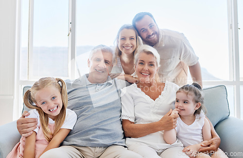 Image of Family, love and children with a girl, parents and grandparents sitting on a living room sofa at home together. Kids, happy or bonding with a senior man, woman and relatives on a couch during a visit