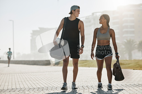 Image of Sports, personal trainer and woman in fitness walking with a soccer ball for cardio exercise, workout and training session. Smile, wellness and happy couple enjoy a healthy city lifestyle in summer