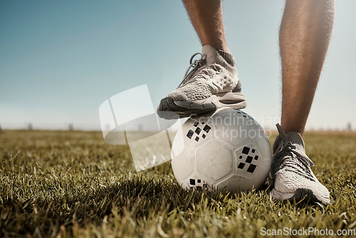Image of Soccer, ball and shoes in sport motivation on grass for training, exercise and fitness in the outdoors. Legs of football player standing for healthy sports workout, practice or game on a green field