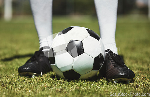 Image of Soccer ball, football player and game of athlete on a sports field for a match wearing shoes. Fitness, training exercise and cardio health of male feet with energy on field, green grass or pitch