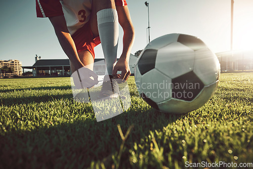 Image of Soccer, ball and tying shoes for sports day of player on the grassy field for match, game or competition. Football professional in motivation getting ready for sport activity, fitness and exercise