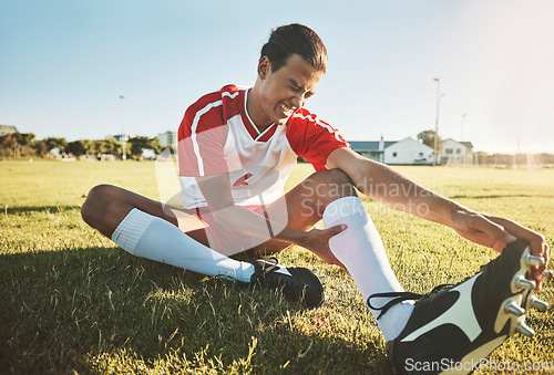 Image of Soccer, athlete and injury on sport field while exercise, workout and practice suffer on game day. Football, health and painful leg from training, sore or muscle for stretching, fallen or foot pain