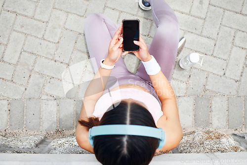 Image of Smartphone, fitness and headphones of woman listening to music on mobile app screen, audio live streaming or outdoor 5g social networking. Sports, runner or athlete girl with tech using phone above