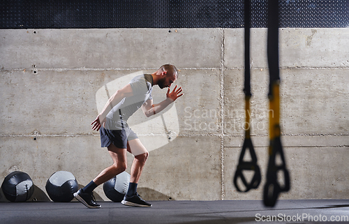 Image of A muscular man captured in air as he jumps in a modern gym, showcasing his athleticism, power, and determination through a highintensity fitness routine