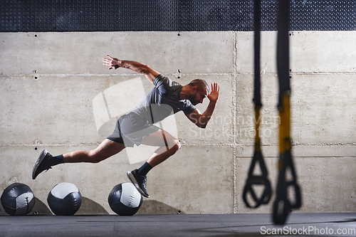 Image of A muscular man captured in air as he jumps in a modern gym, showcasing his athleticism, power, and determination through a highintensity fitness routine