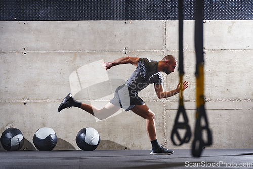 Image of A muscular man captured in air as he jumps in a modern gym, showcasing his athleticism, power, and determination through a highintensity fitness routine