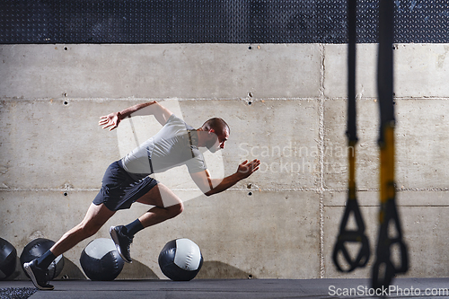 Image of A muscular man captured in air as he jumps in a modern gym, showcasing his athleticism, power, and determination through a highintensity fitness routine