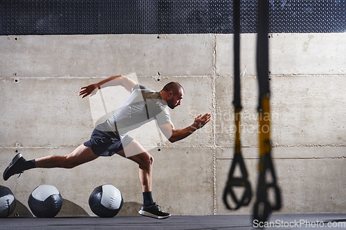 Image of A muscular man captured in air as he jumps in a modern gym, showcasing his athleticism, power, and determination through a highintensity fitness routine